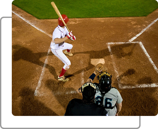 A baseball player swinging at the ball while another player catches it.